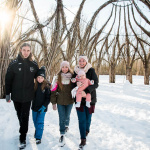 Familie läuft durch einen Weiden im Schnee im Winter im IGA-Park Rostock.