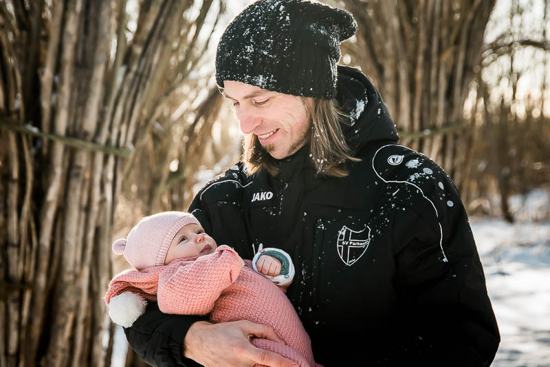 Glücklicher Papa mit seinem Babymädchen zum Fotoshooting in Ribnitz-Damgarten im Winter.