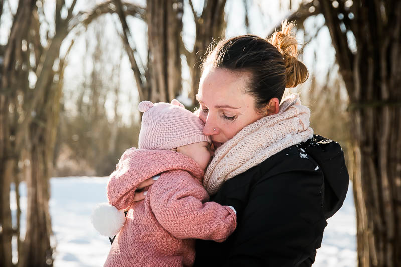 Mama kuschelt ihr neugeborenes Baby im Winter beim Familienfotoshooting in Sanitz.