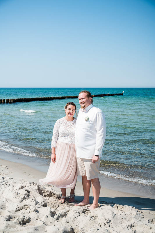 Brautpaar steht am Strand