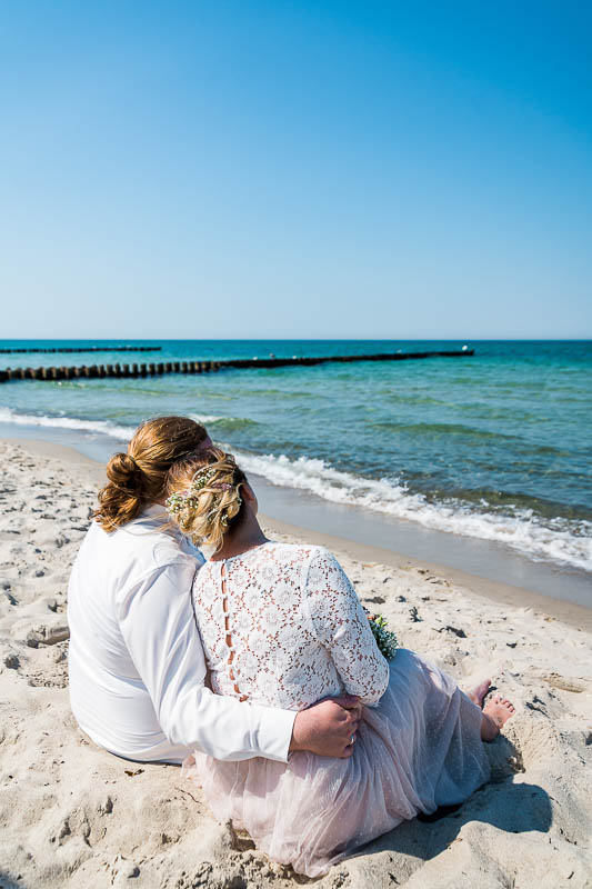 Brautpaar sitzt am Strand von Ahrenshoop