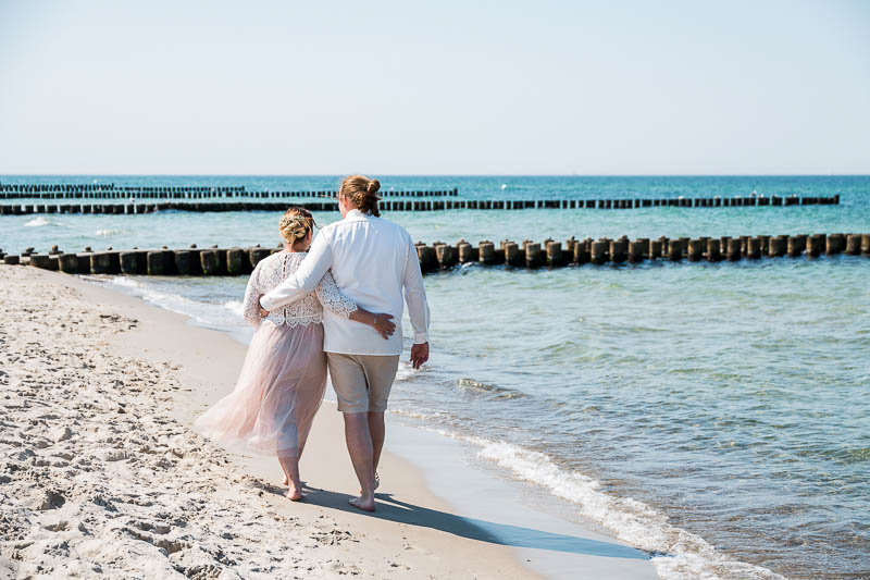 Brautpaar läuft am Strand von Ahrenshoop entlang.