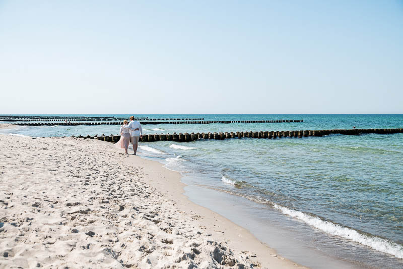 Heirat in Ahrenshoop. Das Brautpaar läuft am Strand entlang