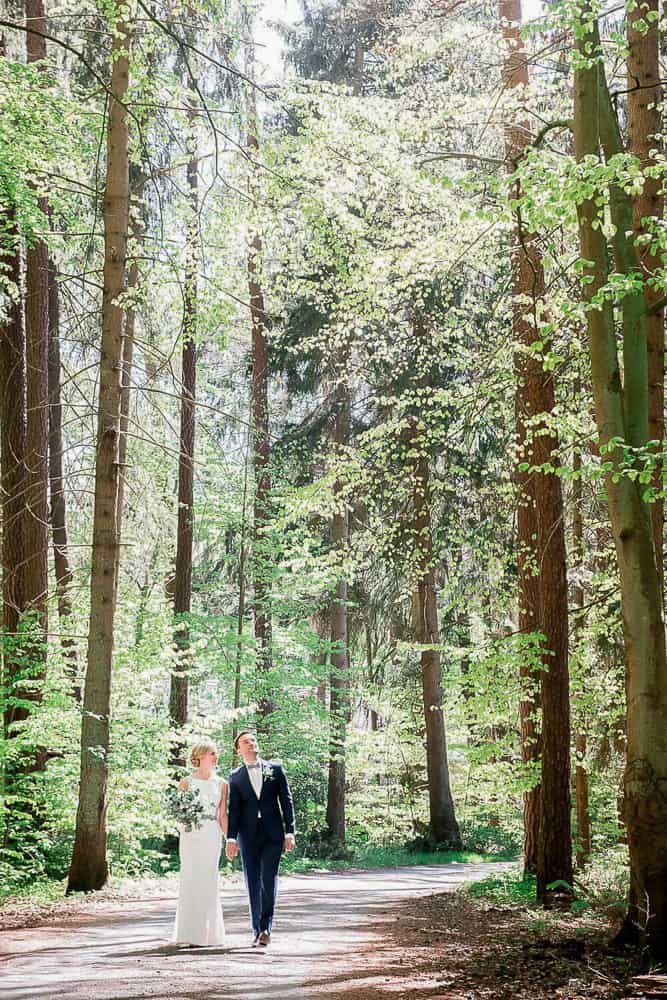 Braut und Bräutigam spazieren im Wald beim Jagdschloss Gelbensande. Dort kann man standesamtlich heiraten. Hochzeitsfotograf.