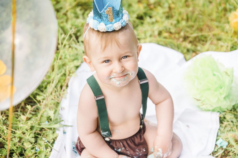 Der erste Geburtstag steht an. Der Junge trägt eine blaue Krone.