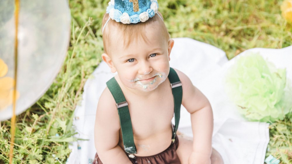 Der erste Geburtstag steht an. Der Junge trägt eine blaue Krone.