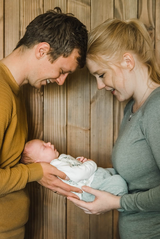 Neugeborenes Baby wird von frischgebackenen Eltern gehalten