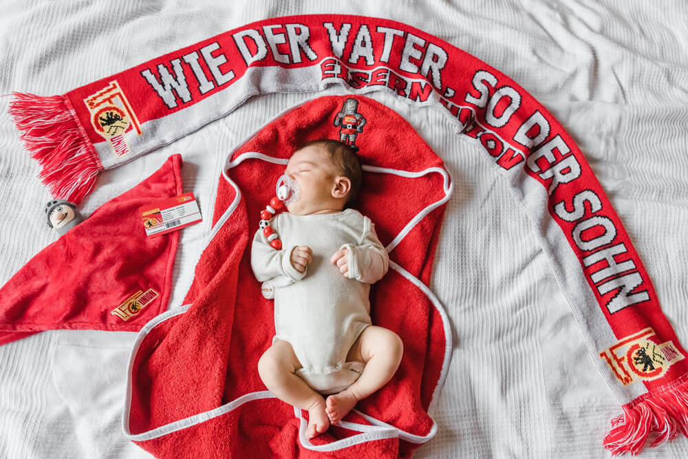 Kleinster Union-Fußball-Fan. Baby in rot weißer Fankleidung.