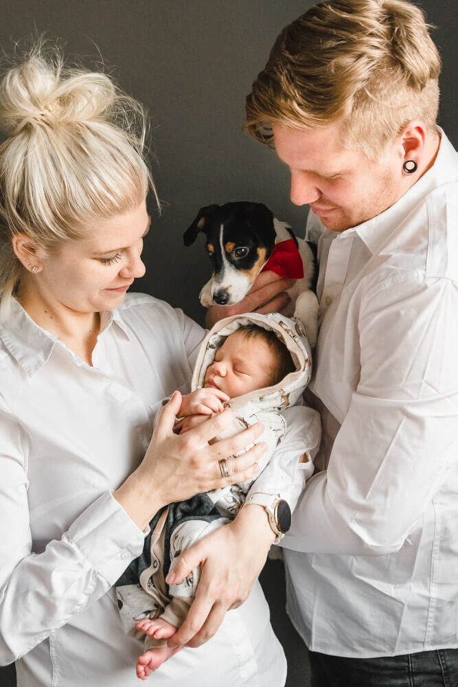 Familienfoto mit Mama, Papa, Baby und Hund beim Babyfotoshooting Zuhause