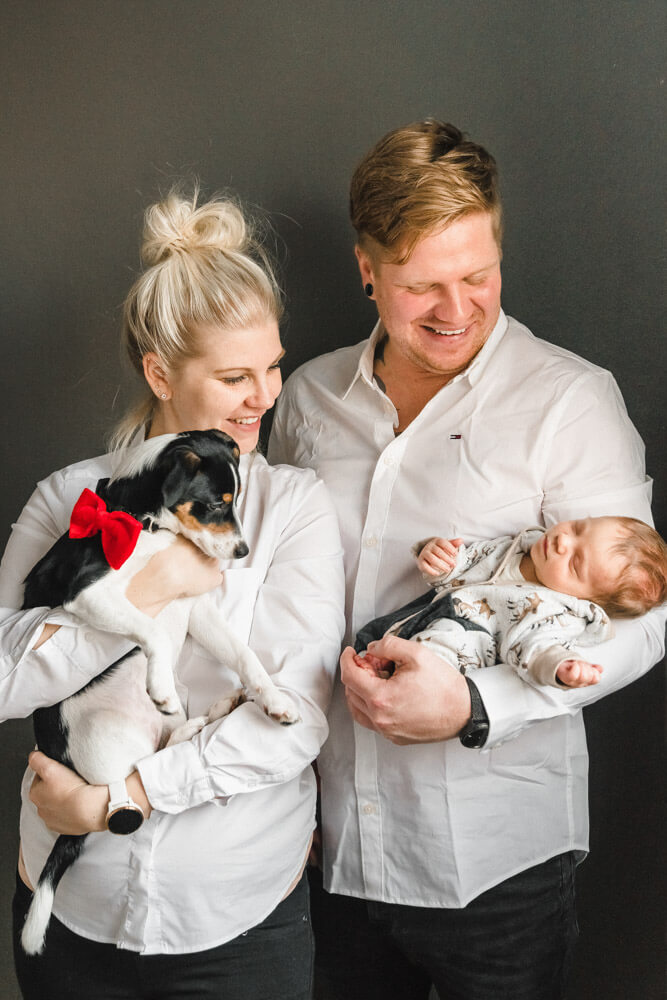 Familienfoto mit Mama, Papa, Baby und Hund Zuhause