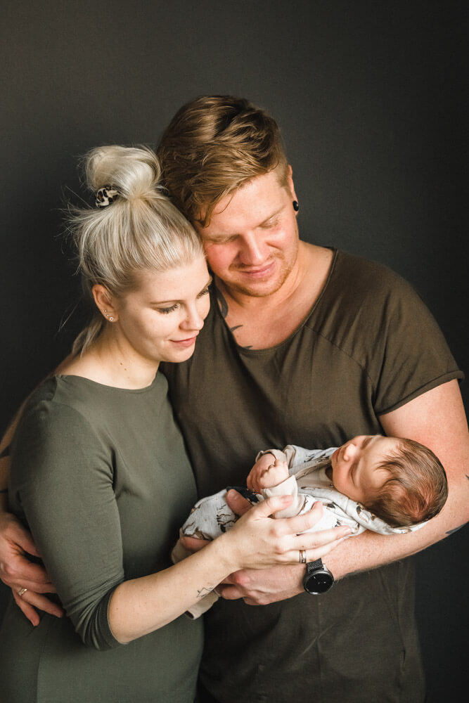 Eltern mit ihrem neugeborenen Sohn beim Familienfotoshooting Zuhause