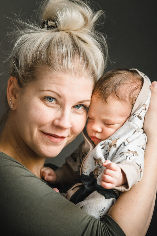 Mama mit ihrem neugeborenen Baby beim Babyfotoshooting Zuhause