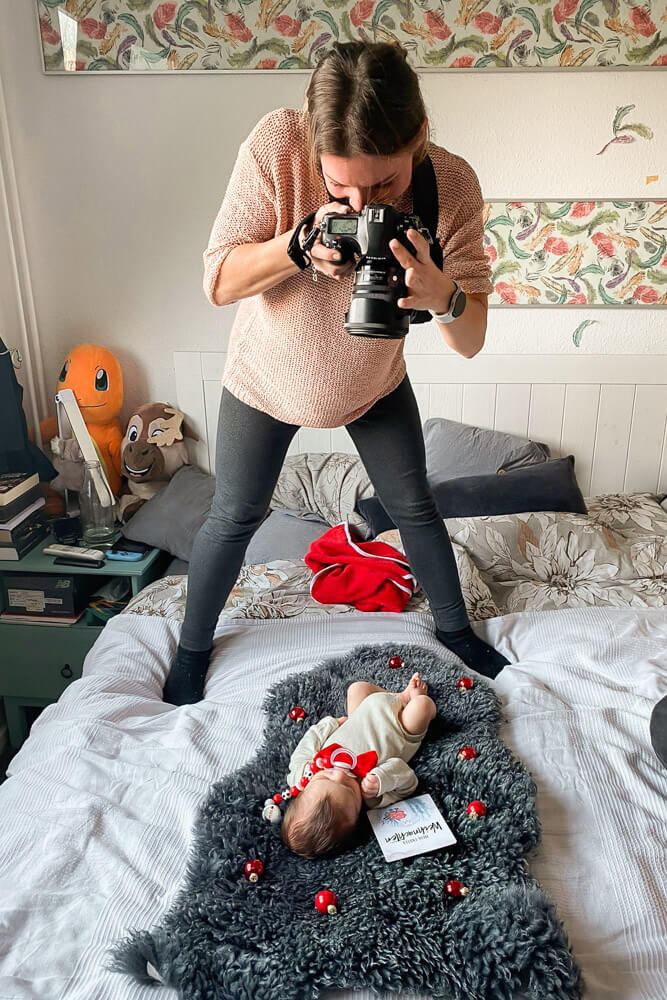 Fotografin fotografiert neugeborenes Baby beim Fotoshooting Zuhause