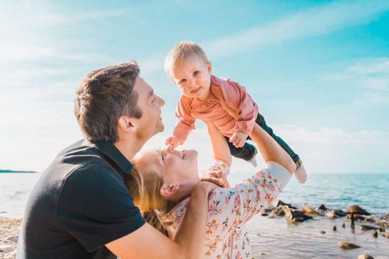 Familienshooting in Heiligendamm am Strand mit Fotograf aus Rotsock. Mama lässt ihr Kleinkind fliegen.