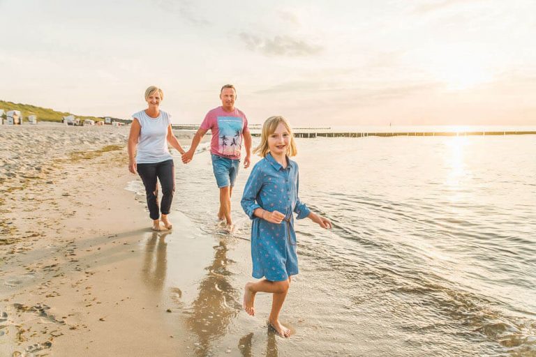 Fotoshooting mit Fotografin aus Rostock am Strand von Graal-Müritz. Die Familie rennt durch die Ostsee.