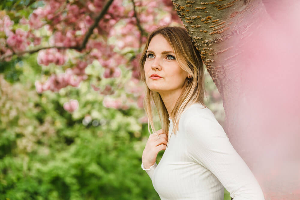 Halbportrait von junger blonder Frau mit der Kirschblüte beim Fotoshooting im Frühling