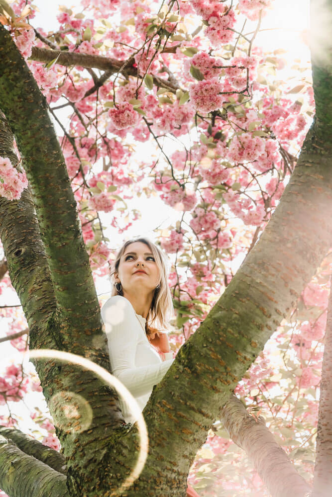 Junge Frau während Fotoshooting im Kirschblüten-Baum