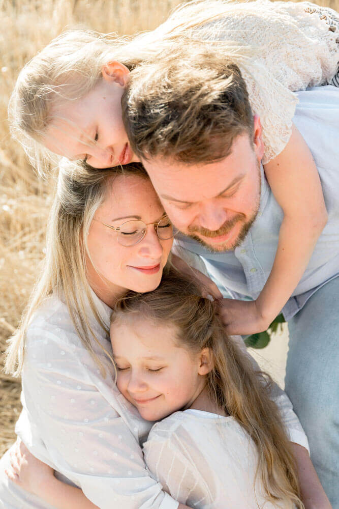 Familie kuschelt beim Fotoshooting - Familienfotos & Babybauchfotos in Rostock