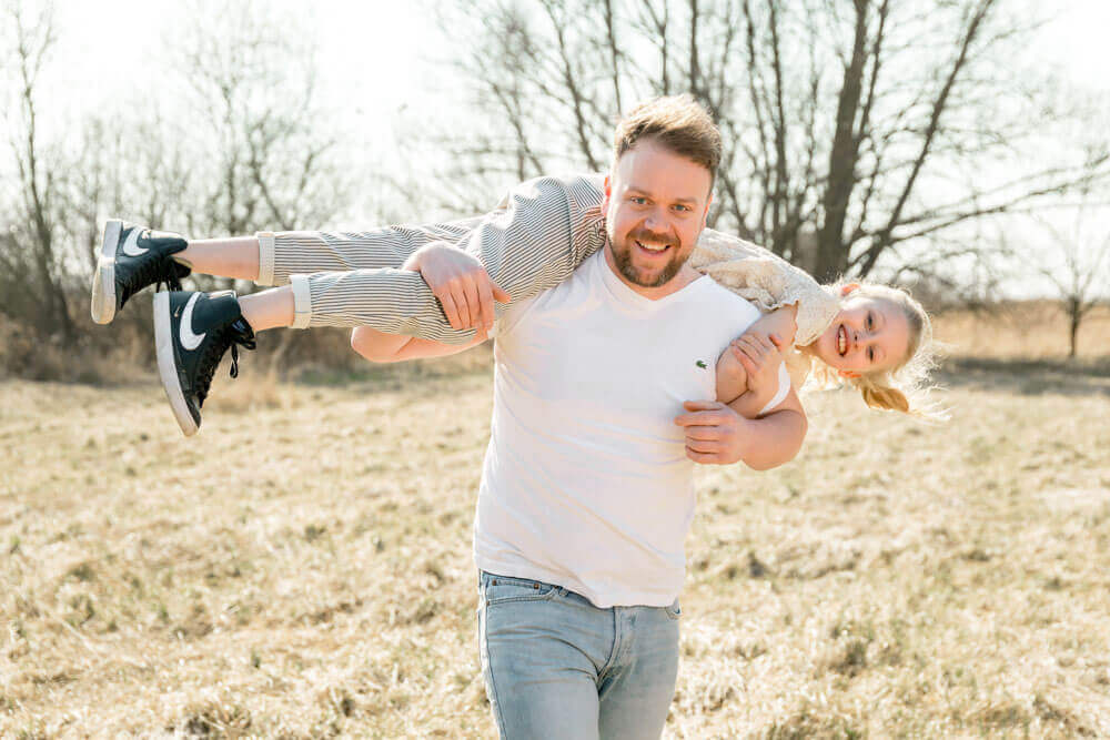 Papa trägt seine große Tochter auf den Schultern - Familienfotografin in Rostock