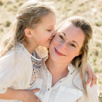 Die kleine Tochter gibt ihrer Mama einen Kuss auf die Wange - Familienfotos in Rostock