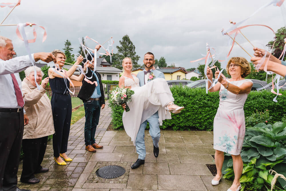 Hochzeitsgäste wedeln mit den Wedding Wands zur Begrüßung des Brautpaares - Hochzeitsfeier in Zingst an der Ostsee
