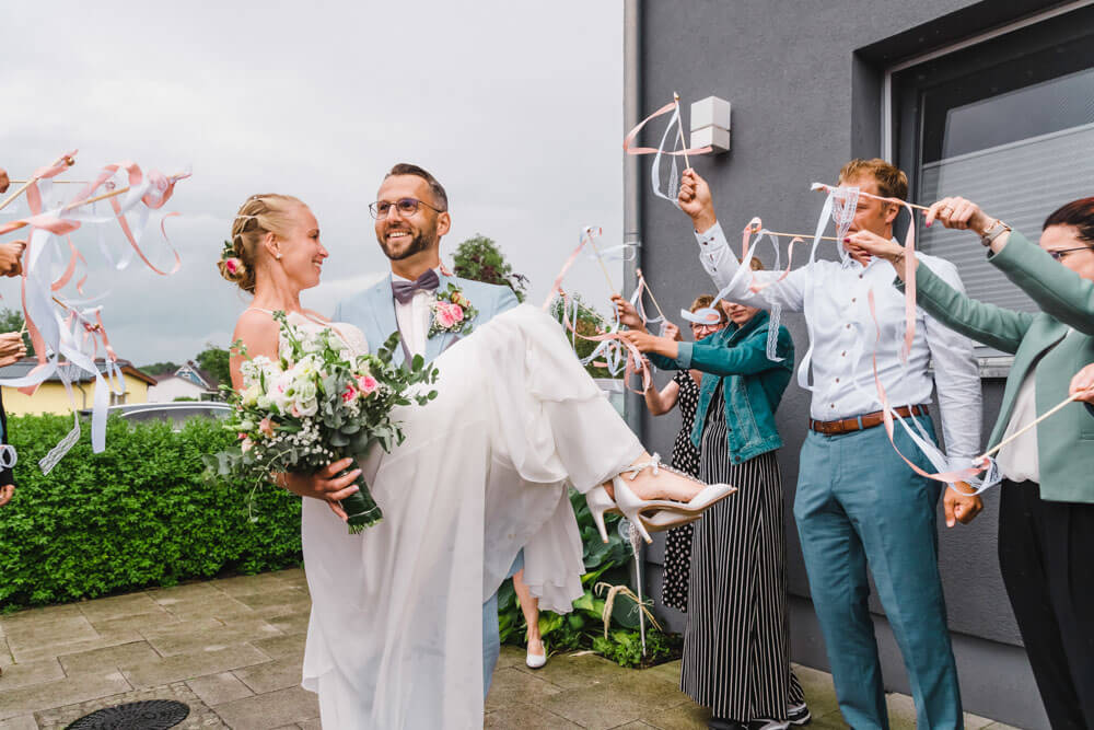 Hochzeitsgäste wedeln mit den Wedding Wands zur Begrüßung des Brautpaares - Hochzeitsfeier in Zingst an der Ostsee