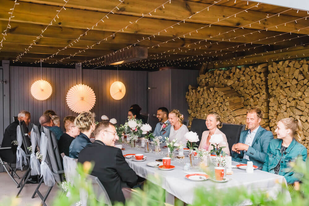 Alle Gäste sitzen regensicher beim Kaffeetrinken und unterhalten sich - Hochzeitsfeier in Zingst an der Ostsee