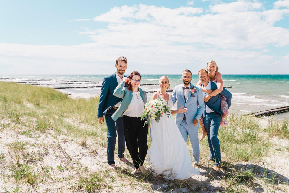 Lockeres Gruppenfoto zur Hochzeit am Strand von Ahrenshoop in den Dünen. Hochzeitsfotograf an der Ostsee (Markgrafenheide, Graal-Müritz, Dierhagen, Ahrenshoop, Wustrow, Prerow, Zingst).