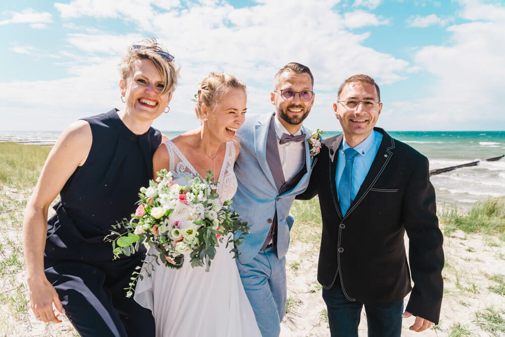 Authentisches Gruppenfoto zur Hochzeit am Strand von Ahrenshoop in den Dünen. Hochzeitsfotograf an der Ostsee (Markgrafenheide, Graal-Müritz, Dierhagen, Ahrenshoop, Wustrow, Prerow, Zingst).