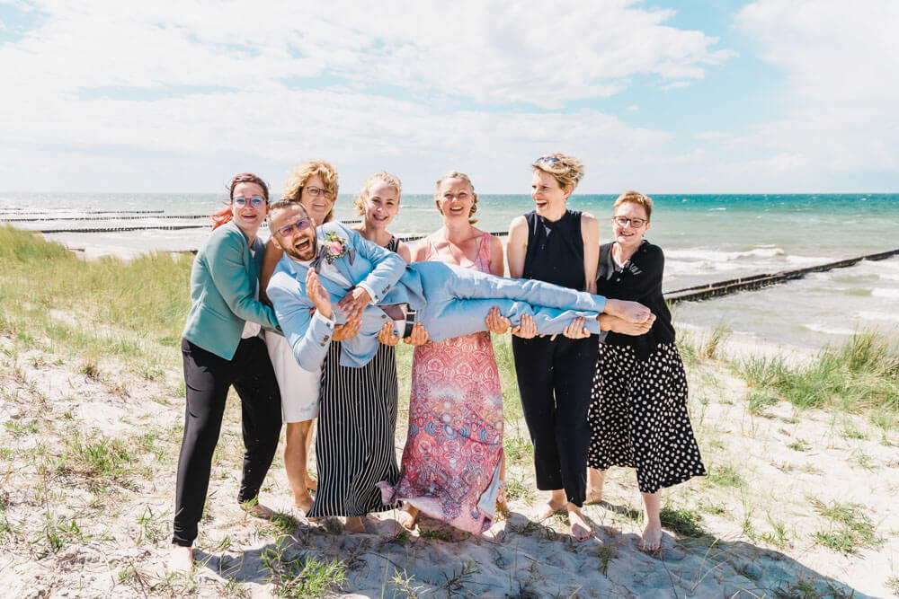 Lustiges Gruppenfoto zur Hochzeit am Strand von Ahrenshoop in den Dünen. Hochzeitsfotograf an der Ostsee (Markgrafenheide, Graal-Müritz, Dierhagen, Ahrenshoop, Wustrow, Prerow, Zingst).