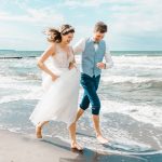 Hochzeitsfoto: Brautpaar rennt am am Strand entlang.
