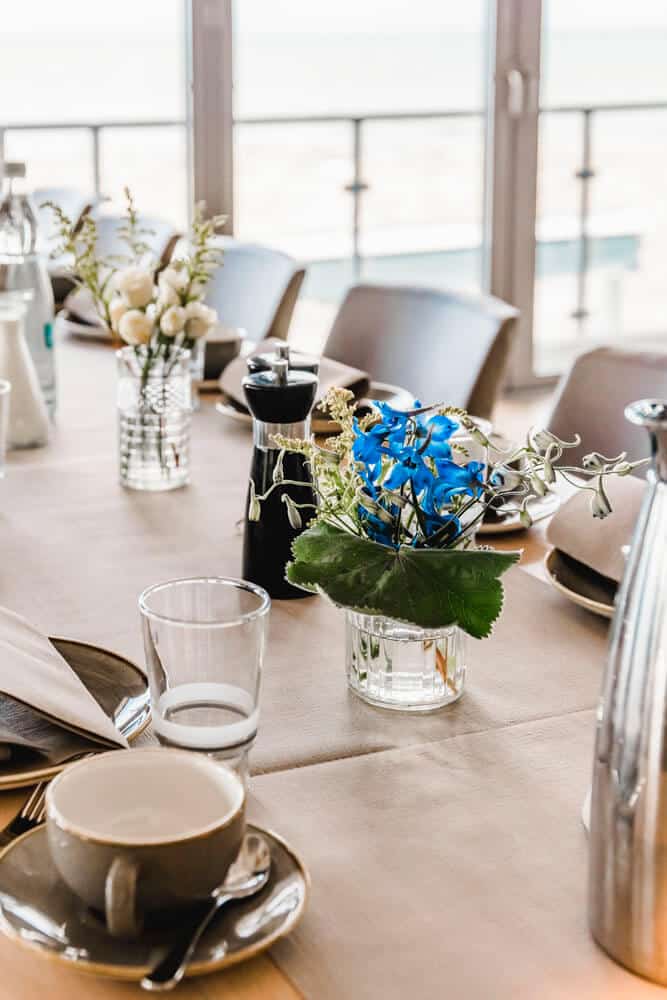 Gedeckter Tisch in der Hochzeitslocation "Blaue Boje" in Markgrafenheide mit Blick auf den Ostseestrand.
