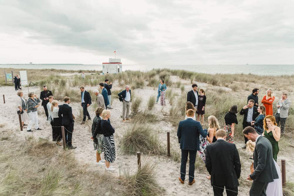 Hochzeitsreportage in Markgrafenheide. Die Hochzeitsgäste genießen den Ausblick auf die Ostsee vor dem Strandrestaurant "Blaue Boje".