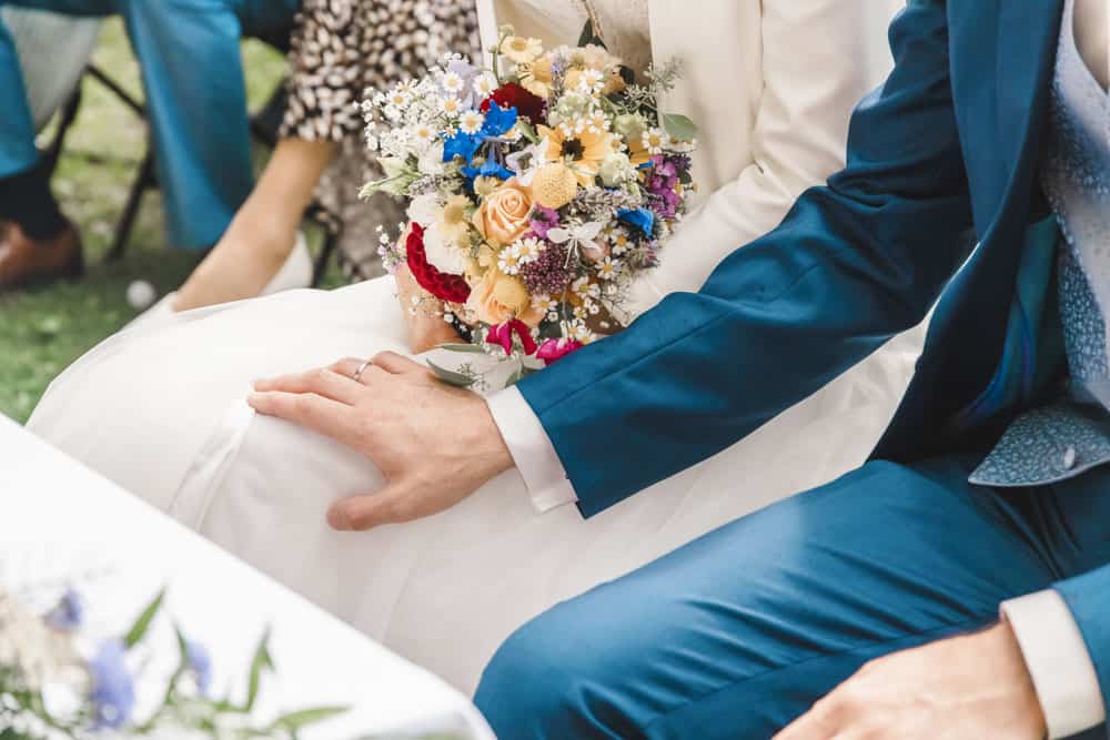 Detailaufnahme: Bräutigam legt Hand auf das Bein seiner Braut.