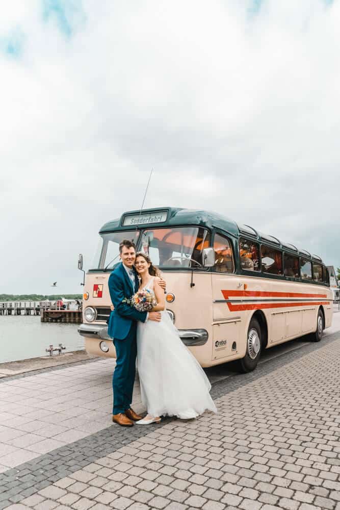Brautpaar steht vor gemieteten Omnibus Ikarus 55 in Ribnitz-Damgarten.