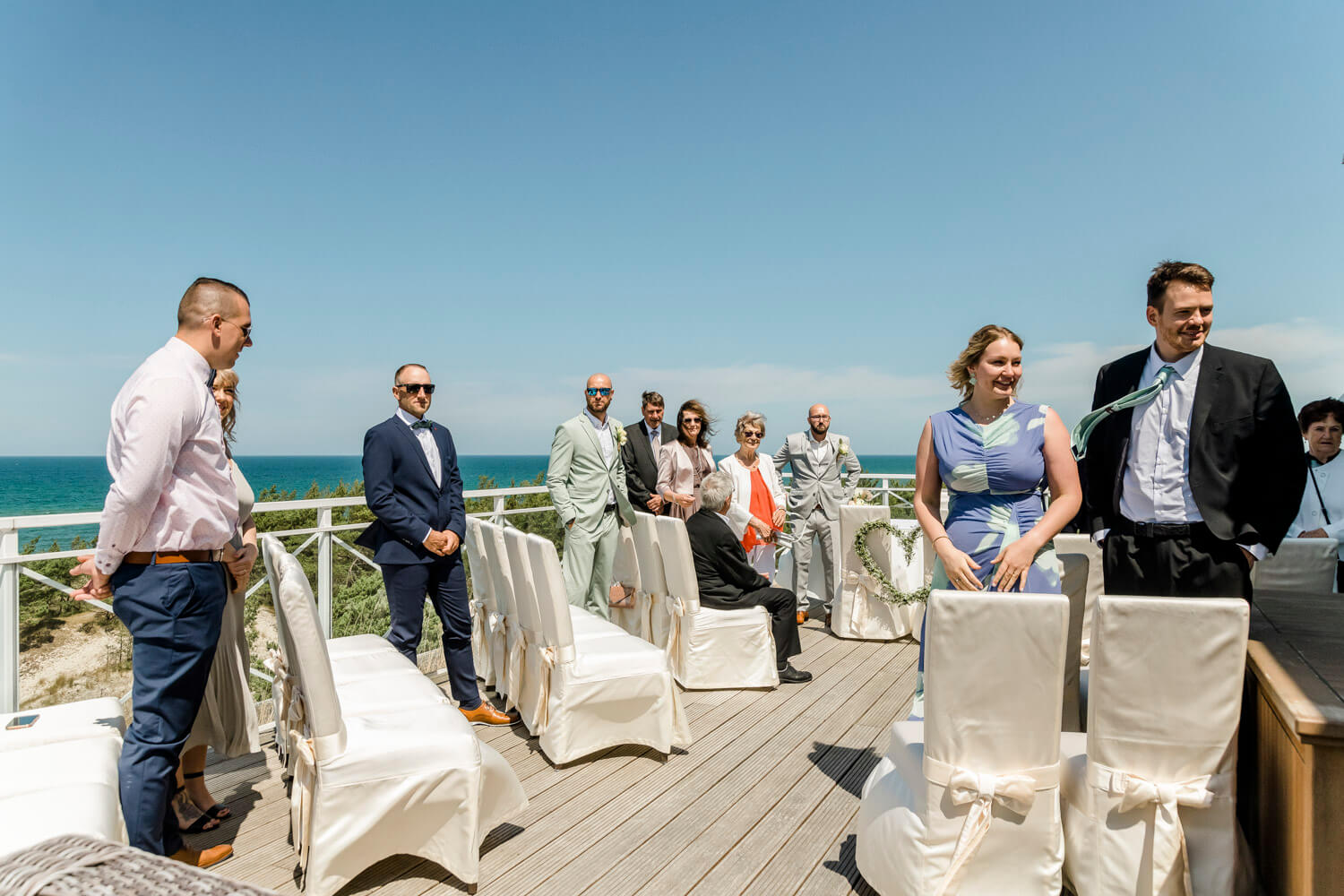 Die Hochzeitsgäste warten auf der Dachterrasse mit Blick auf die Ostsee auf die Braut