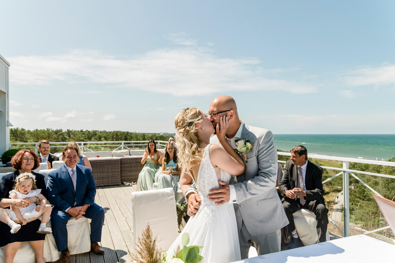 Der erste Kuss als verheiratetes Ehepaar mit Blick auf das Meer. Hochzeitsfotograf an der Ostsee.