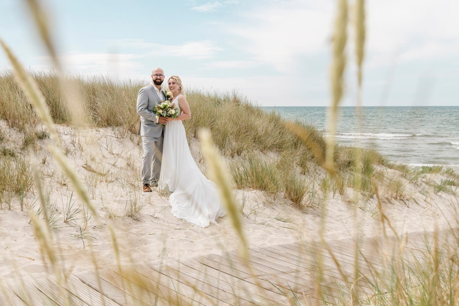 Strandhochzeit in Mecklenburg-Vorpommern. Brautpaar steht in den Dünen von Dierhagen auf dem Darss. Hochzeitsfotograf.