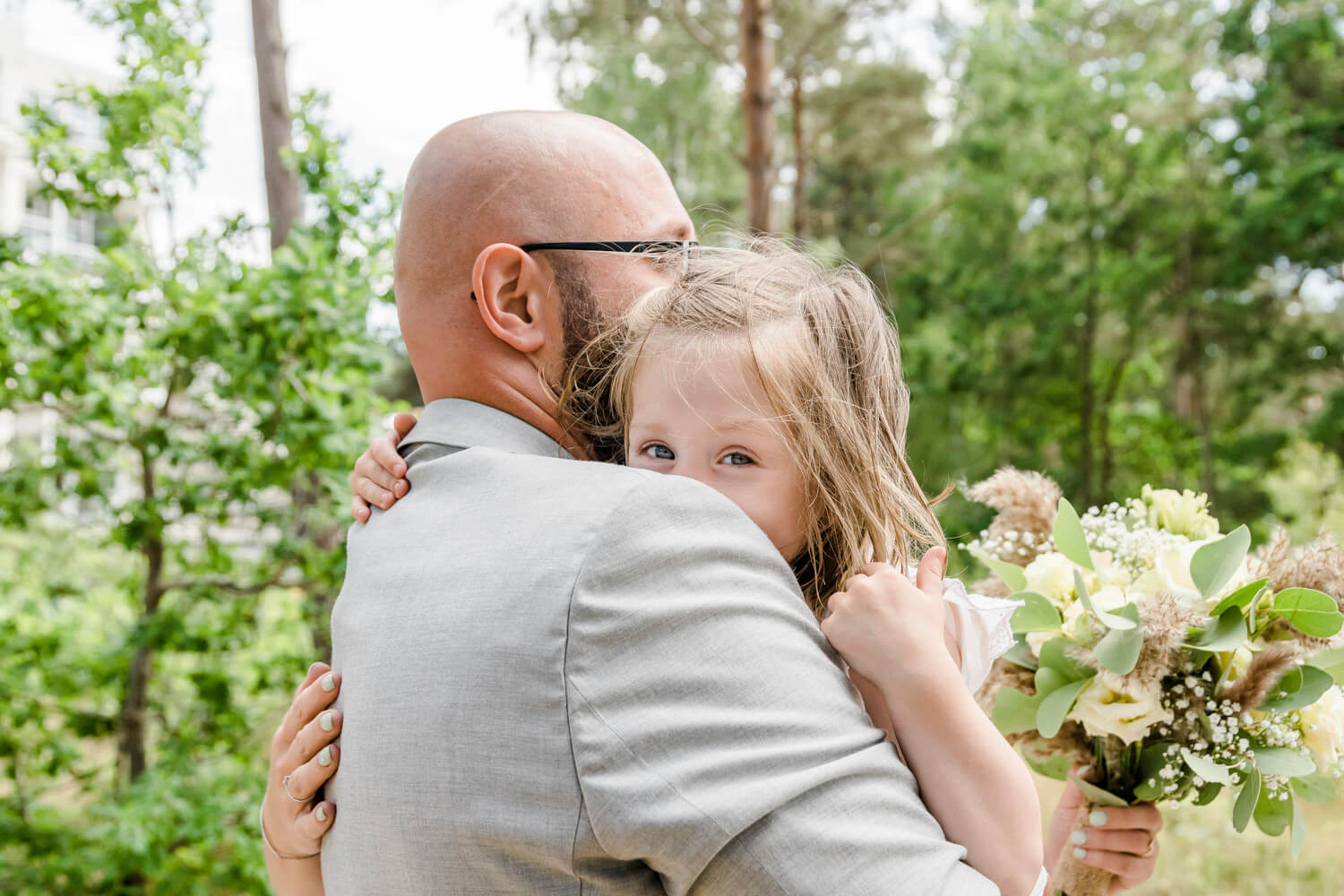 Papa und Tochter kuscheln beim Brautpaarfotoshooting. Familienfotograf Dierhagen.