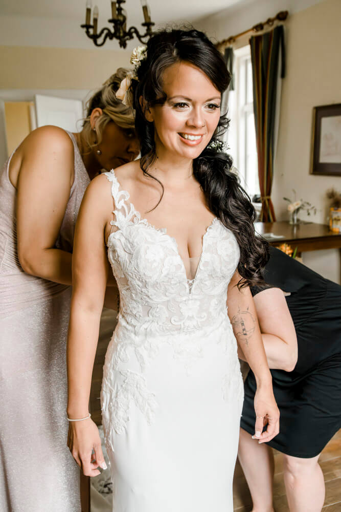 Die Braut zieht ihr Brautkleid an für ihre Hochzeit in MV.
