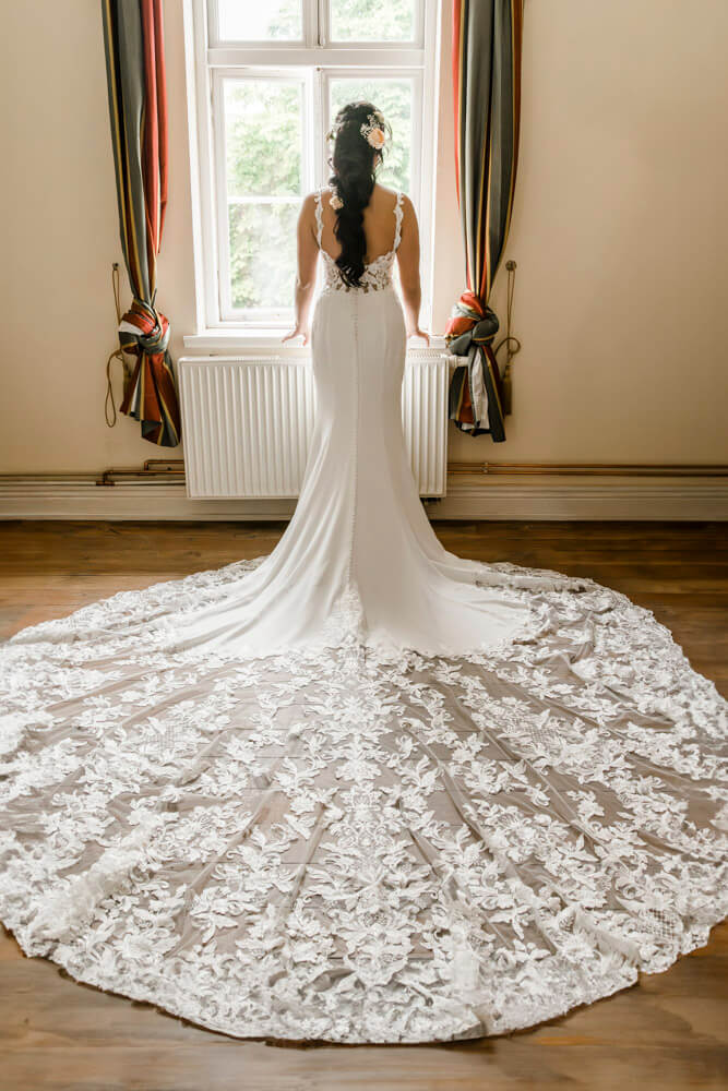 Die Braut von hinten mit einer riesigen Schleppe vom Brautkleid. Hochzeitsfotograf Landkreis Rostock.