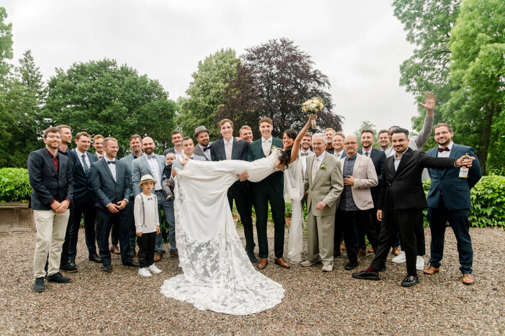 Gruppenfoto zur Hochzeit: Alle Männer und die Braut wird hoch gehoben