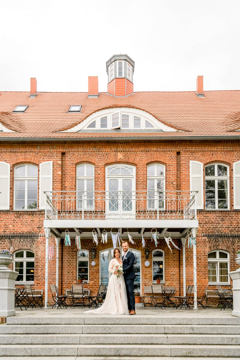 Hochzeitsfeier im Schloss Pütnitz in Ribnitz-Damgarten. Das Brautpaar steht vor der Hochzeitslocation.