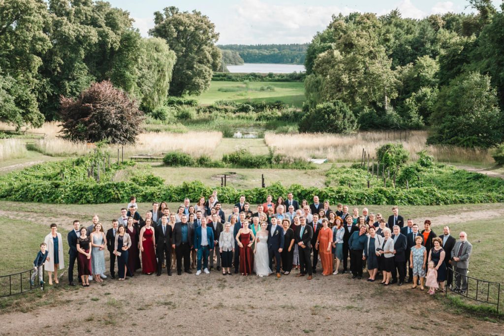 Gruppenfoto zur Hochzeitsfeier im Schloss Vietgest mit Blick in die Natur