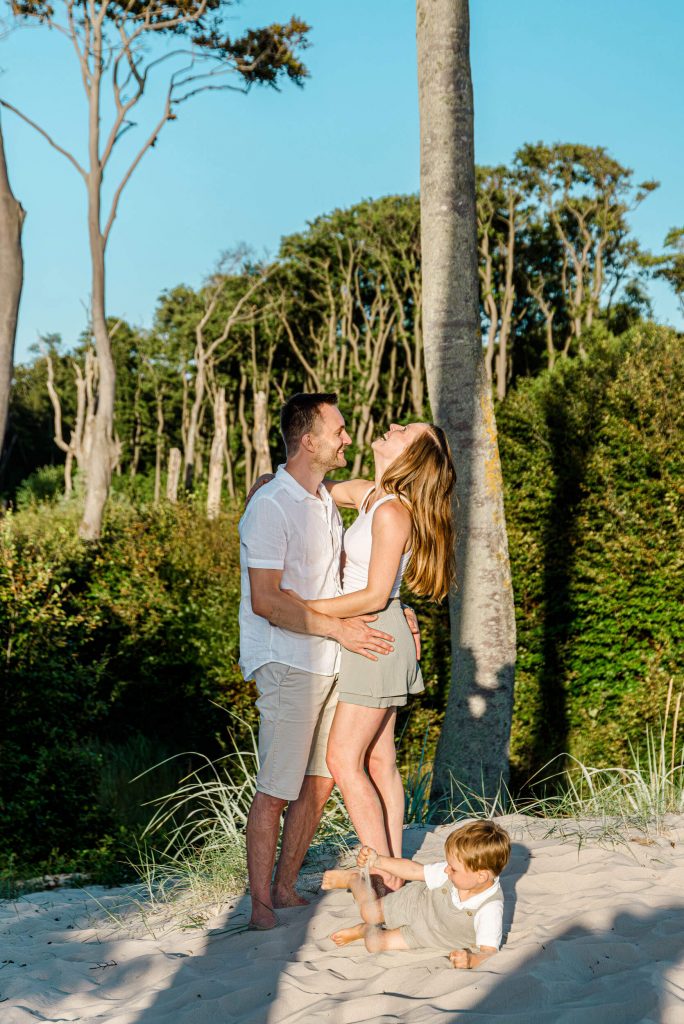 Familienfotoshooting am Strand mit Eltern und Kind, fröhliche Momente in der Natur, ideal für Familienporträts und Erinnerungen.