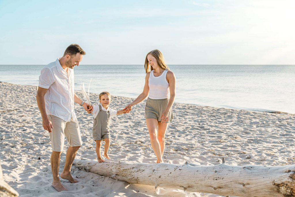 Familie spaziert fröhlich am Strand entlang