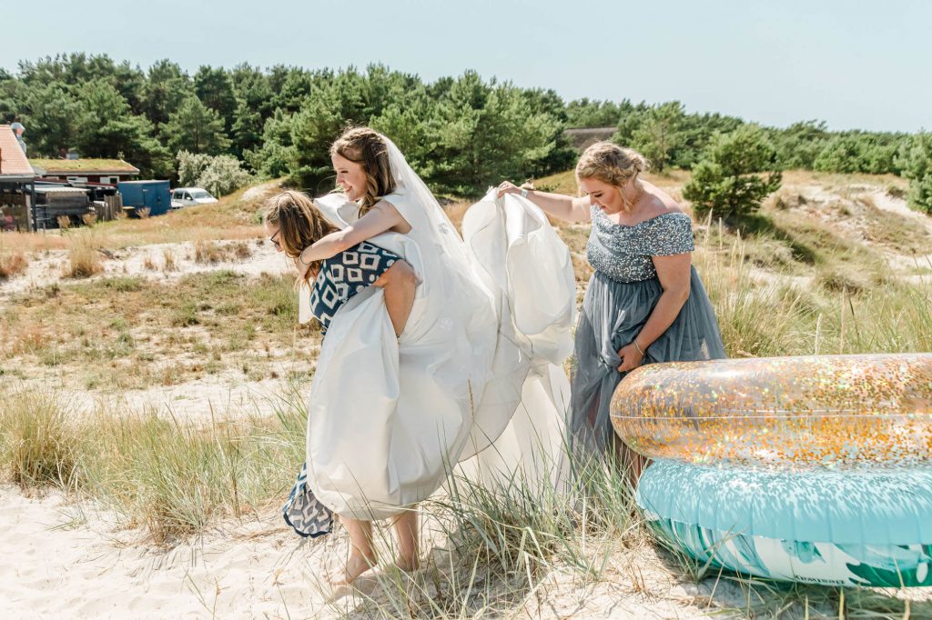 Braut und Freunde feiern Hochzeit am Strand