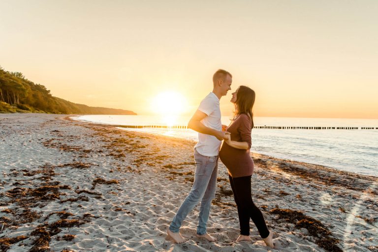 Paar umarmt sich am Strand bei Sonnenuntergang