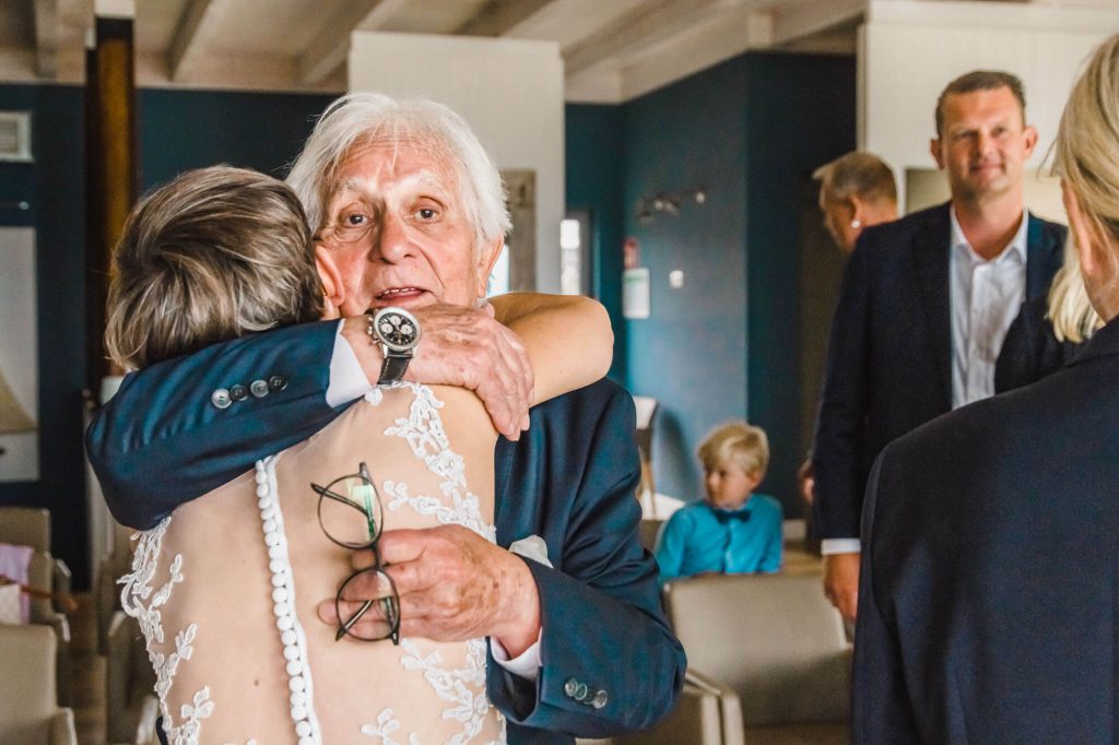 Älterer Mann umarmt Frau bei einer Feier