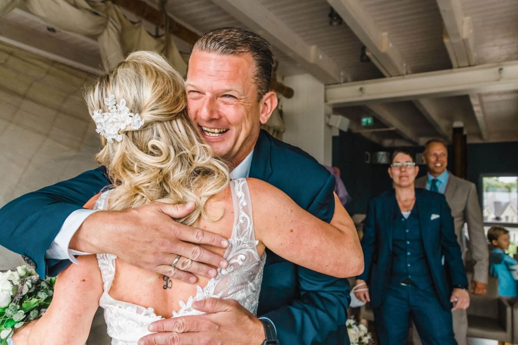 Glückliches Hochzeitspaar umarmt sich liebevoll drinnen